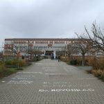 Modern building entrance with paved walkway and trees